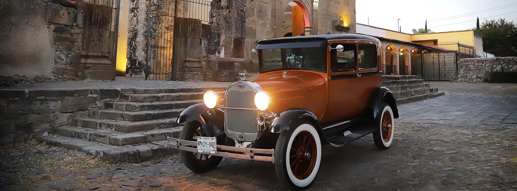 Auto antiguo de Auto Época frente a una construcción histórica